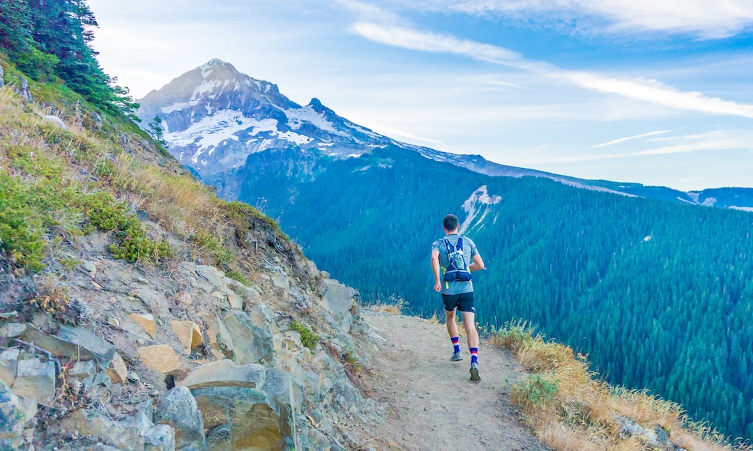 Man jogging on a path with a backpack